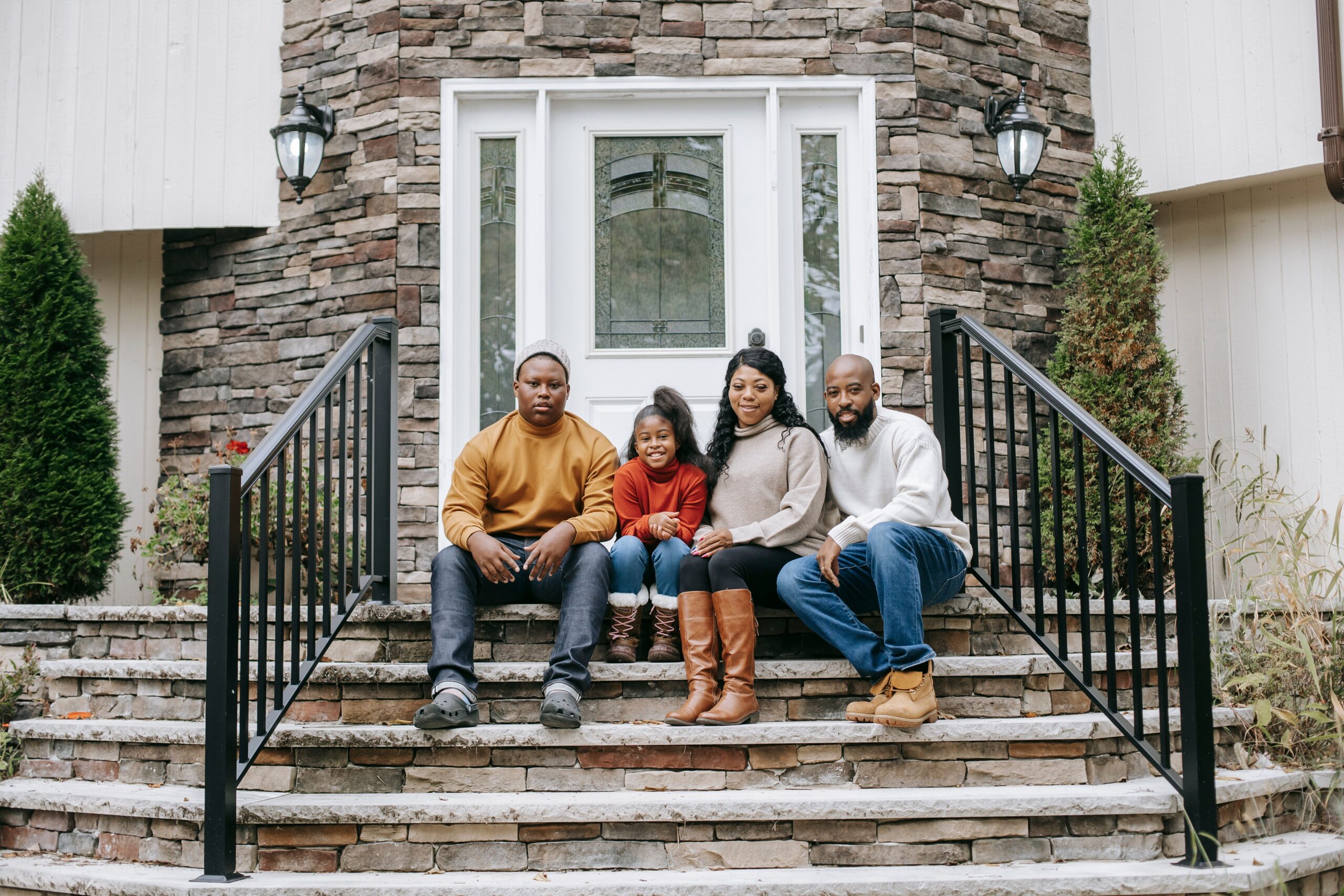Black family sitting outside their home