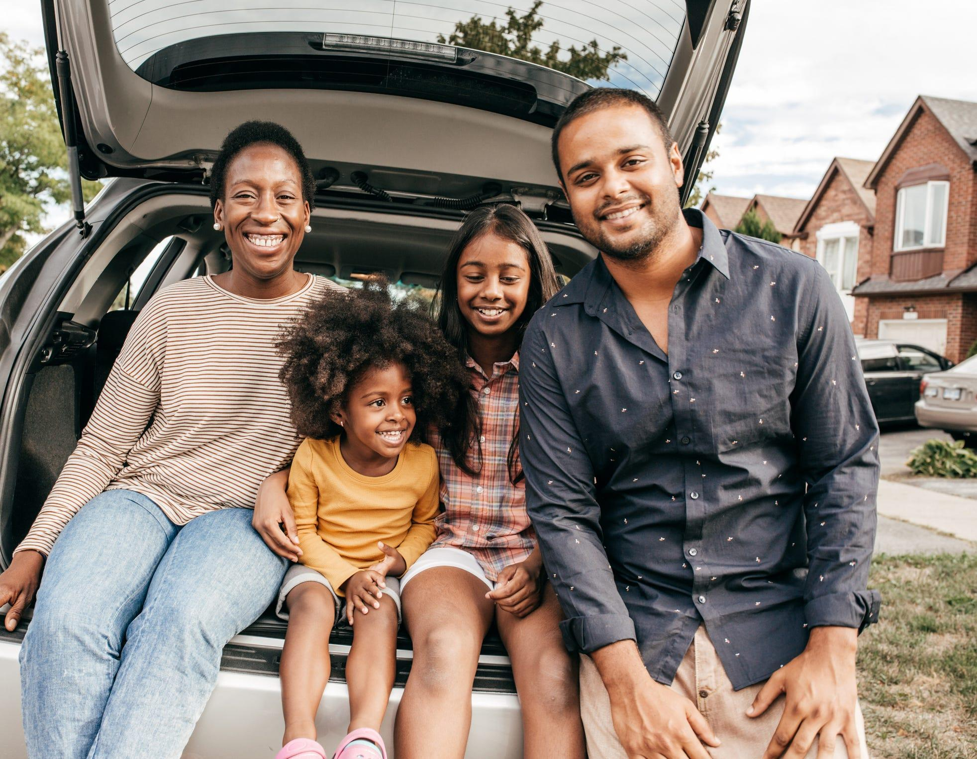 Family sitting together at the back of their car