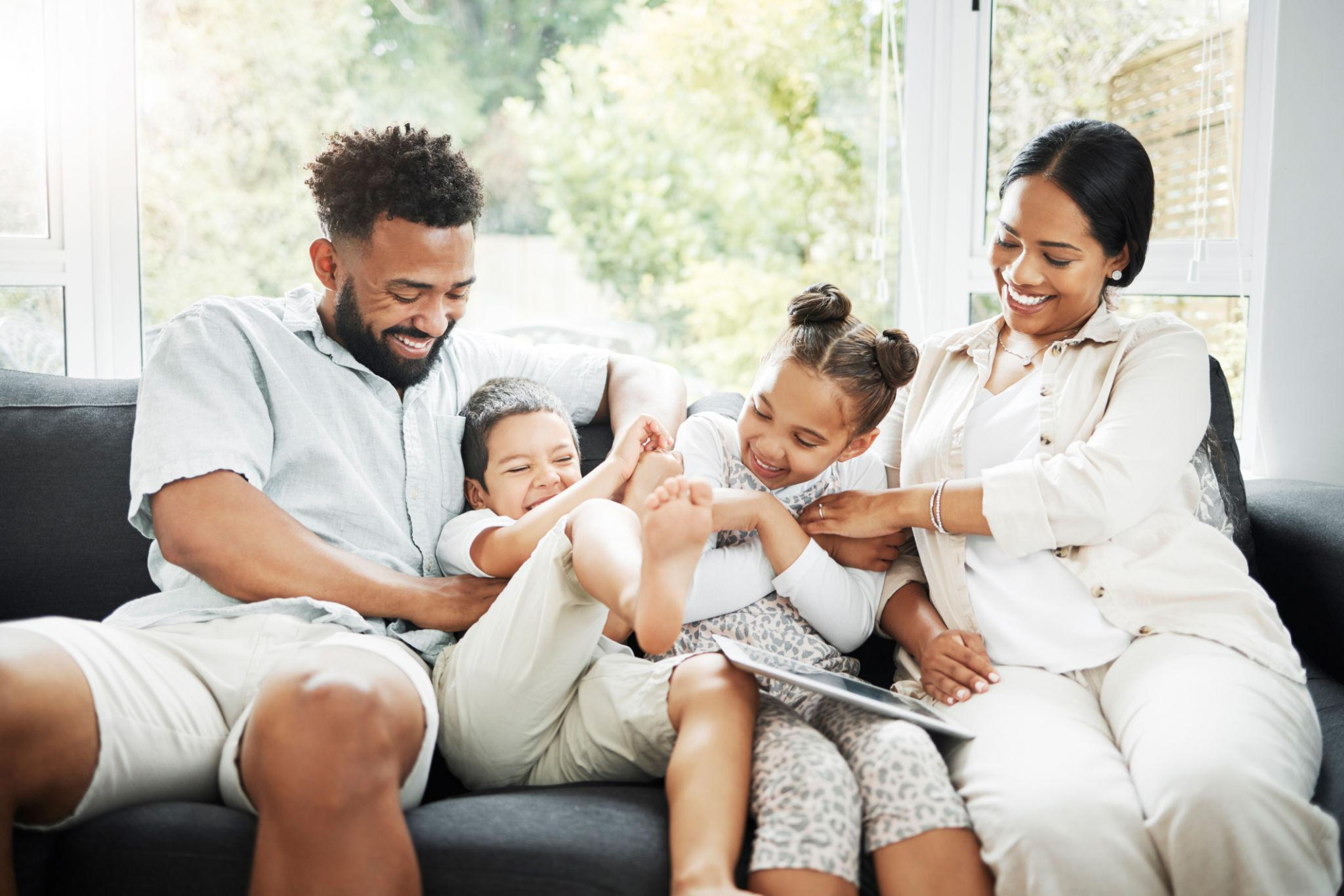 Parents and two children enjoying time on a sofa